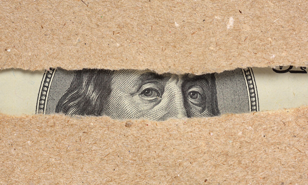 A magnifying glass hovering over a ledger, symbolizing scrutiny of financial data.