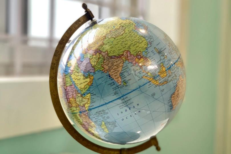 Fasset logo with a global map in the background, symbolizing expansion.
