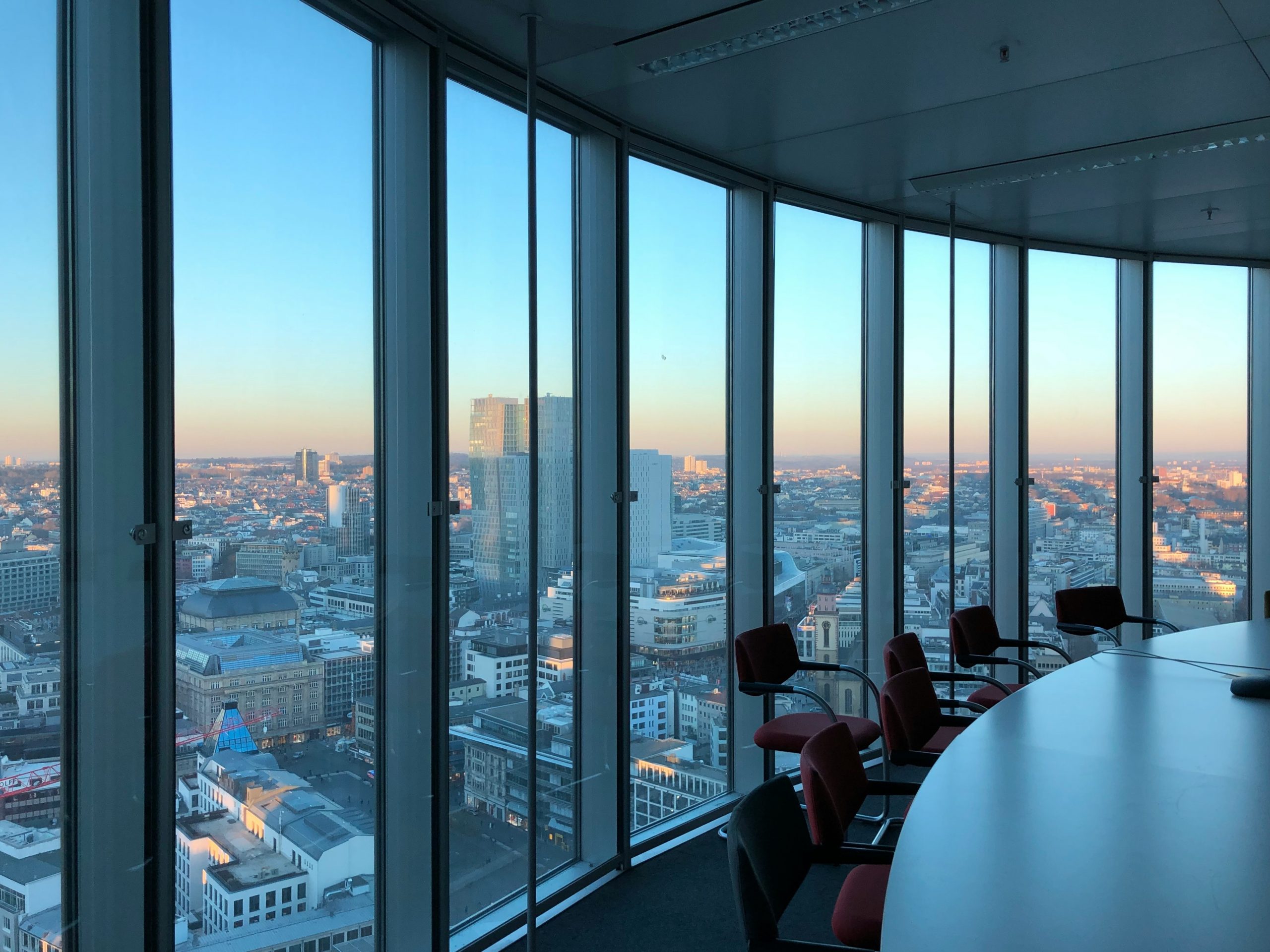 A professional discusses financial charts with executives in a modern boardroom.