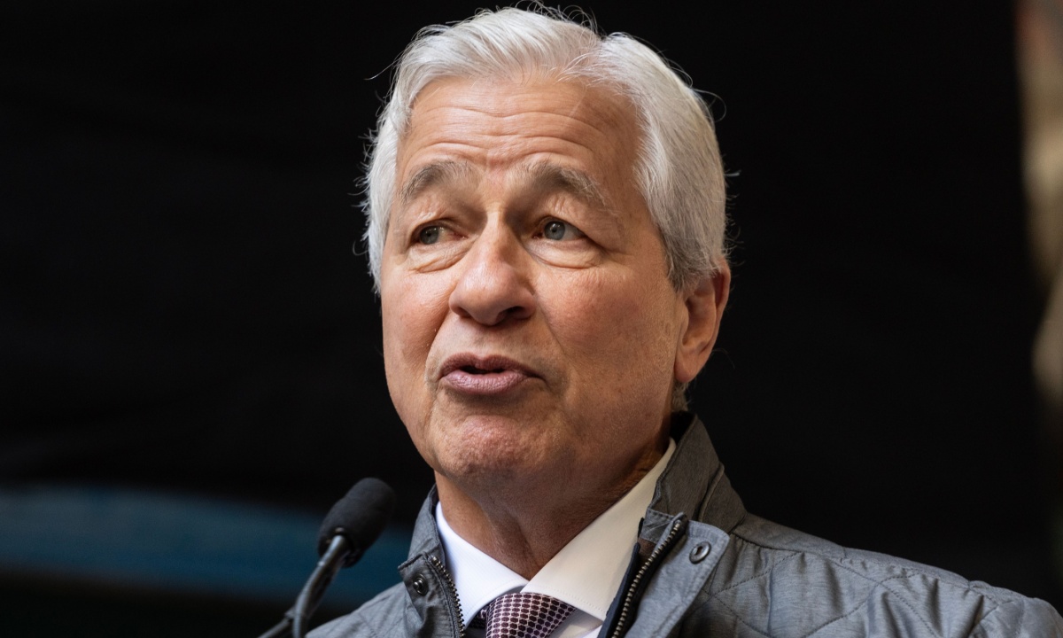 Jamie Dimon speaking at an event, with a JPMorgan Chase logo visible.