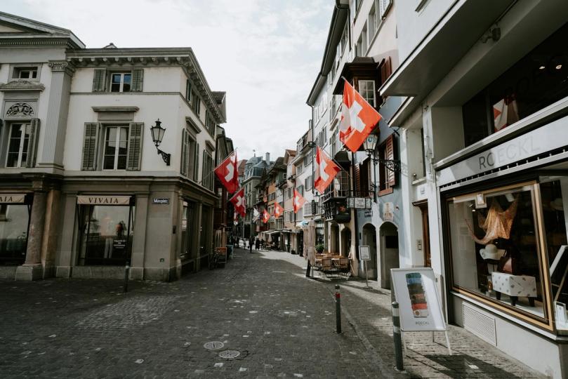 Swiss flag with a downward-trending Bitcoin graph superimposed.