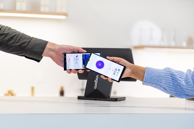 A close-up of a smartphone screen displaying a payment confirmation, with a credit card hovering nearby.