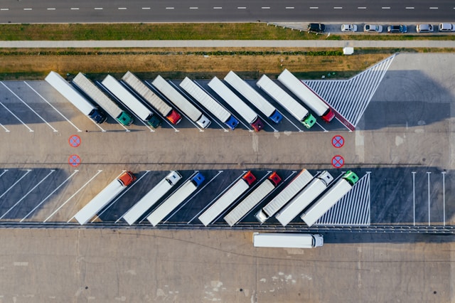 A stylized graphic representing a network of interconnected nodes, with subtle truck silhouettes in the background, symbolizing the ASCEND program.