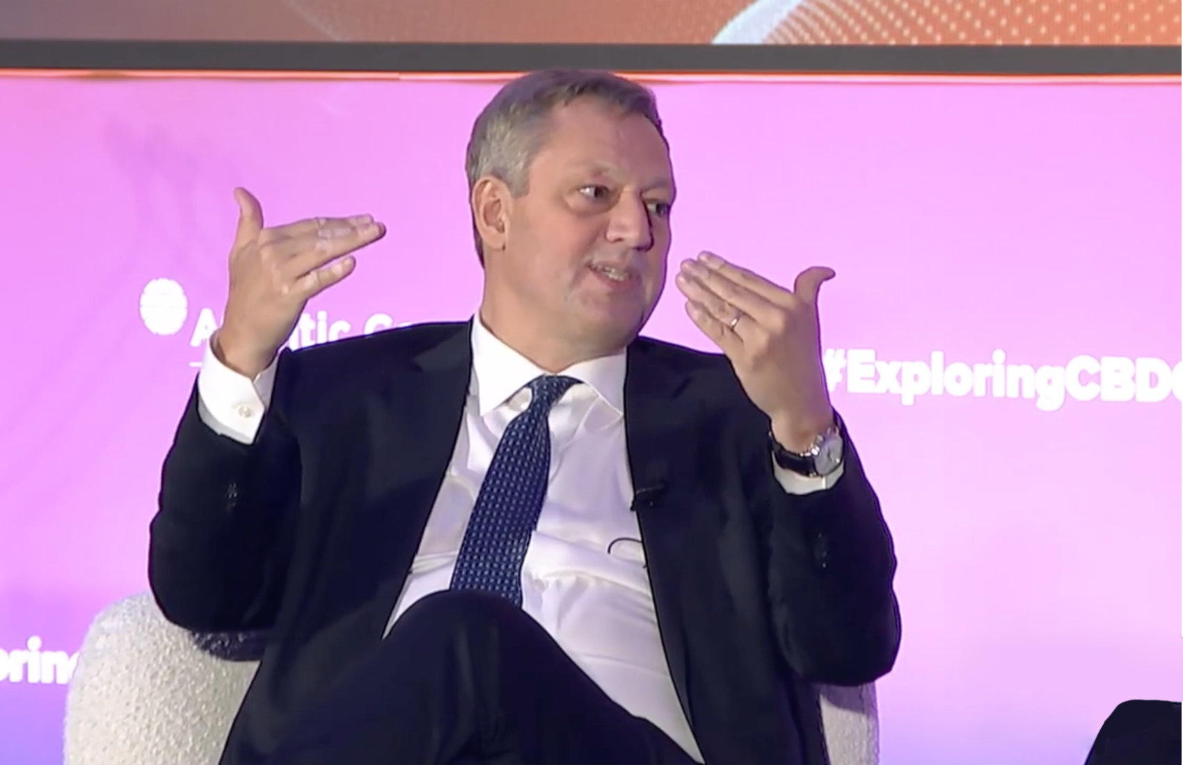 IMF Financial Counsellor Tobias Adrian presenting on tokenized finance amid blockchain graphics